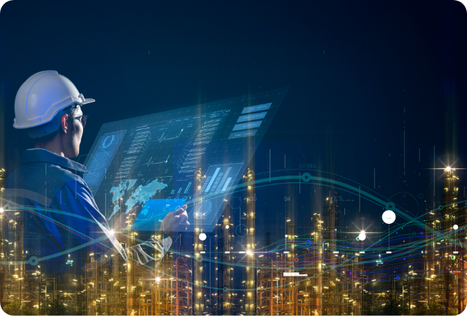 A modern manufacturing facility at night with an overlaid image of a person working on a laptop