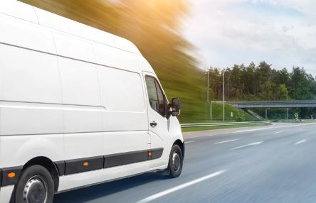 A white van driving on the highway