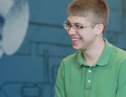 A man in a green shirt is smiling