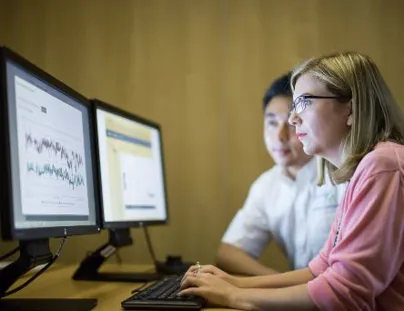 Two people are looking at a computer screen