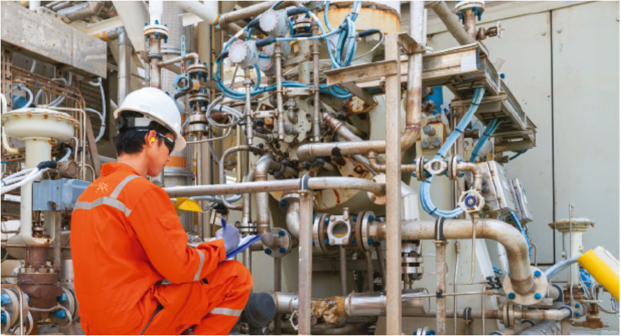 A man in an orange uniform is working on a pipe (1)