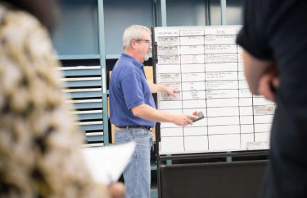A man is standing in front of a whiteboard