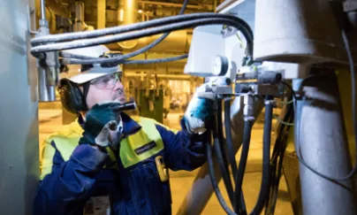 A man in a safety vest is working on a machine