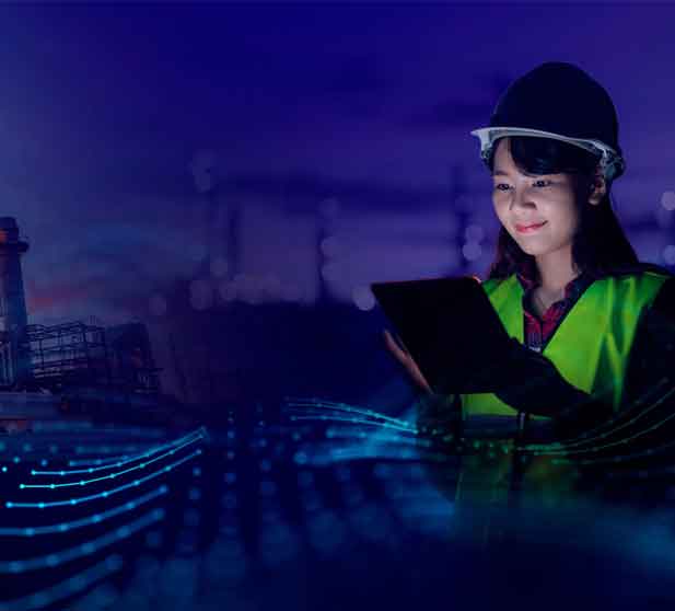 A woman in a hard hat and safety vest holding a tablet computer