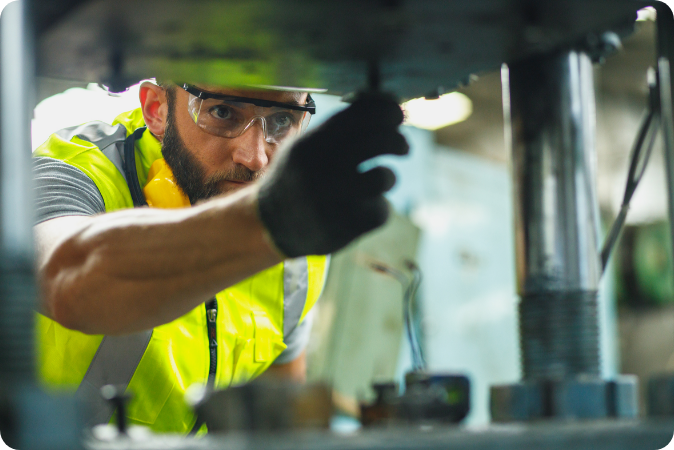 A man in safety vest working on a machine