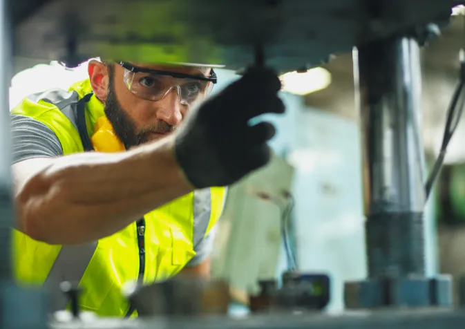 A man in safety vest working on a machine