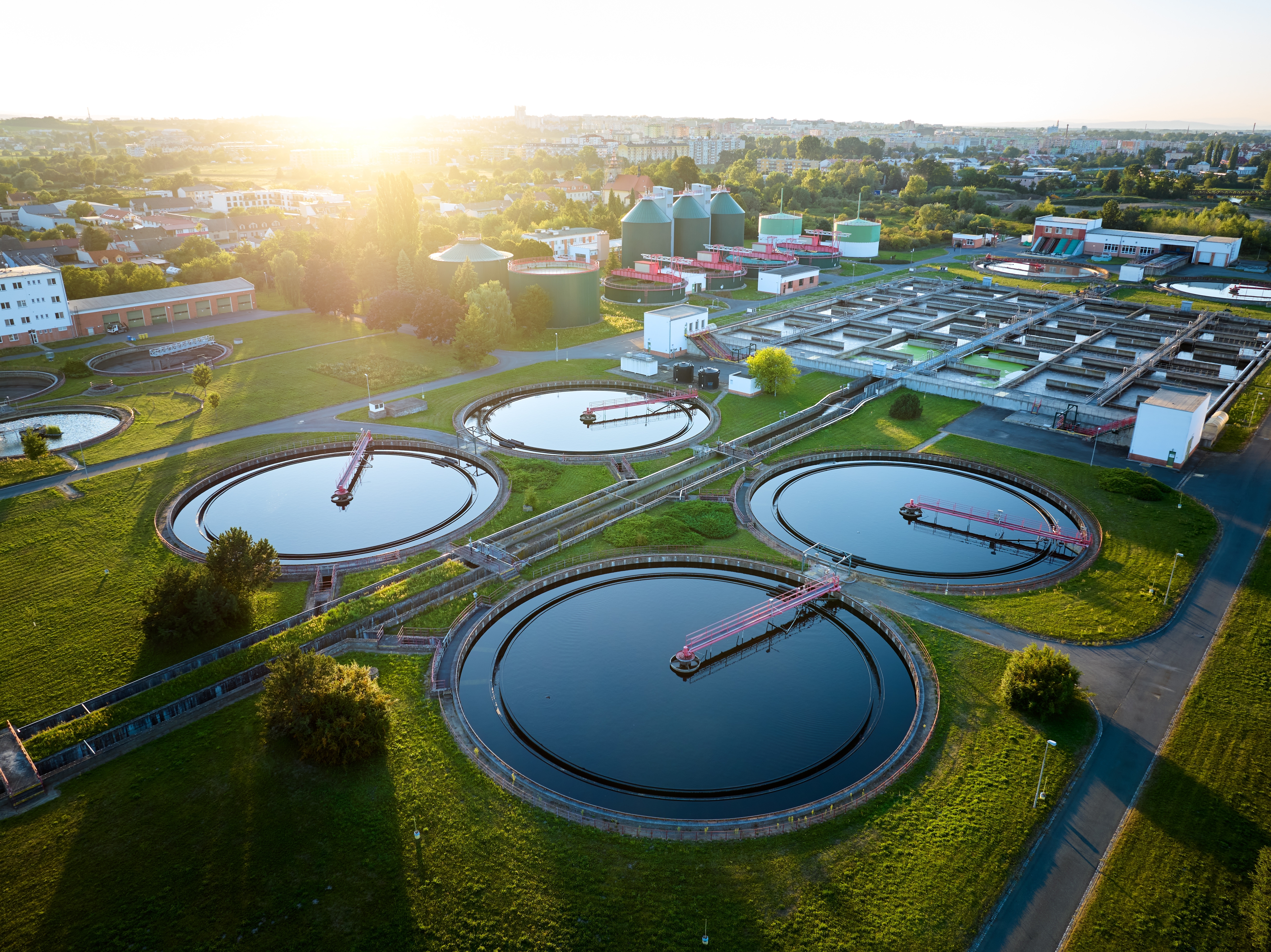 Aerial view of a modern wastewater treatment plant with circular clarifier tanks.