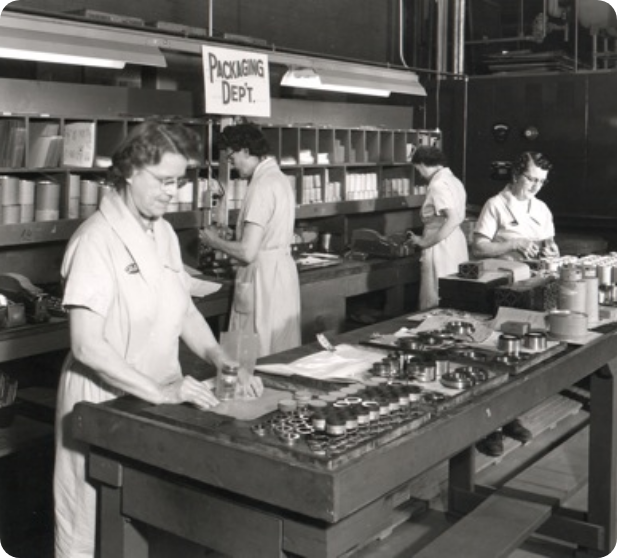 Women working in a factory with a large table