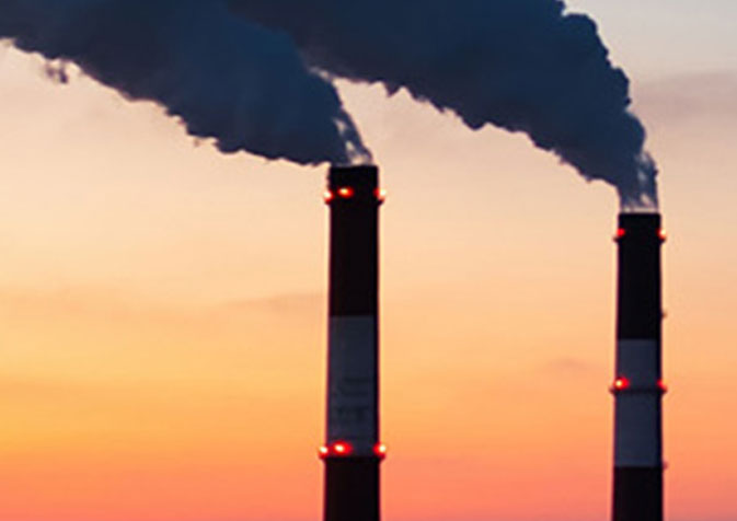 Two chimneys with smoke coming out of them