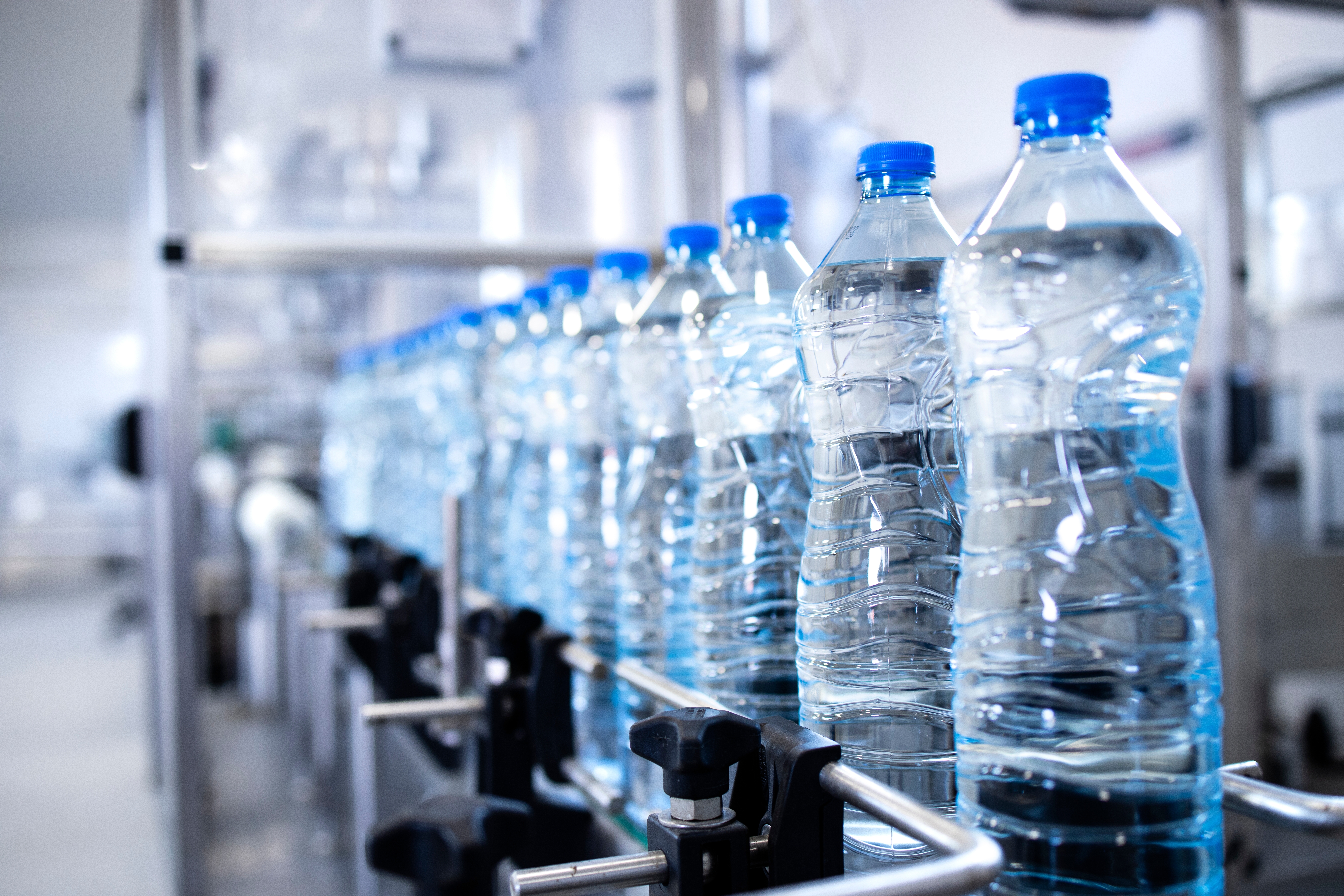 Plastic water bottles on a production line in a bottling plant.
