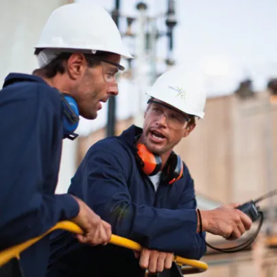 Two men in hard hats talking to each other