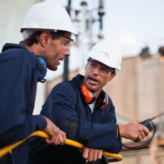 Two men in hard hats talking to each other