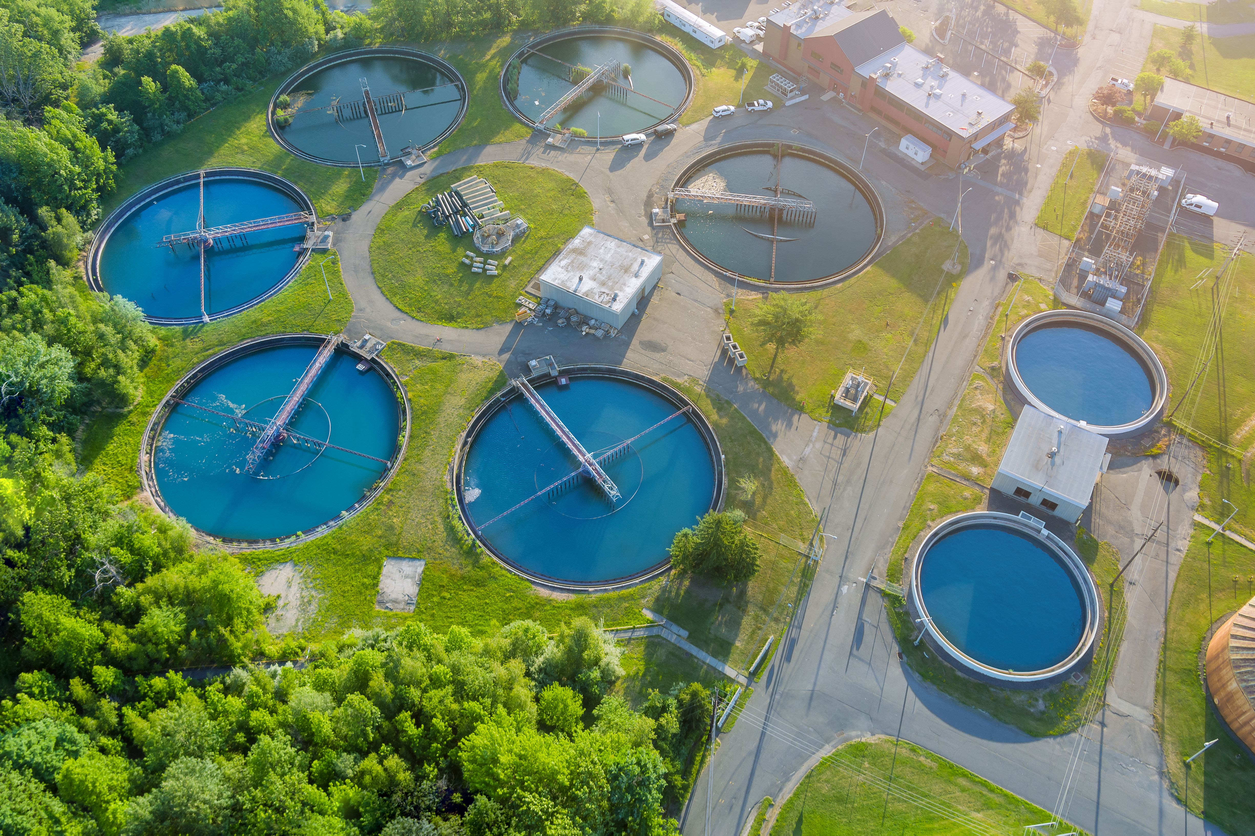 Aerial view of a water treatment plant with multiple circular settling tanks.